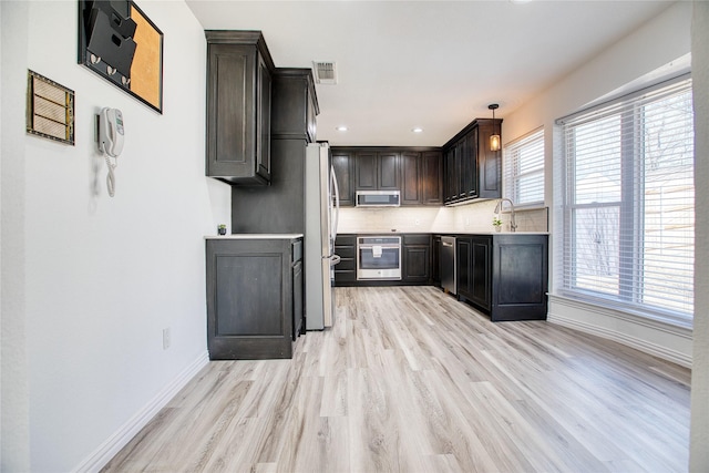 kitchen with light wood-style flooring, visible vents, baseboards, light countertops, and appliances with stainless steel finishes