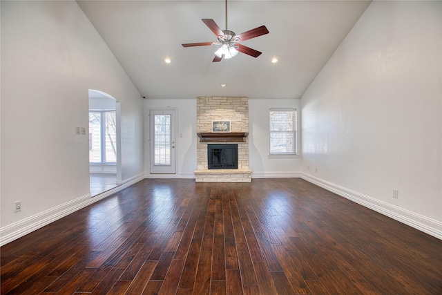 unfurnished living room featuring dark wood-style floors, high vaulted ceiling, a fireplace, and baseboards