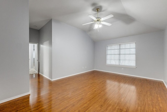 unfurnished room featuring ceiling fan, baseboards, vaulted ceiling, and wood finished floors