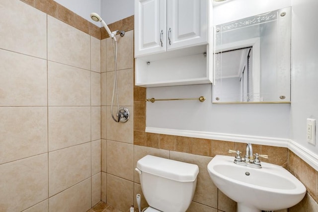 full bathroom featuring a sink, a tile shower, and toilet