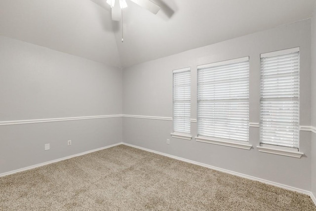 carpeted empty room with lofted ceiling, ceiling fan, and baseboards