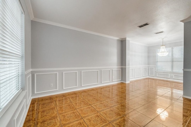 unfurnished room featuring a chandelier, tile patterned flooring, visible vents, and crown molding