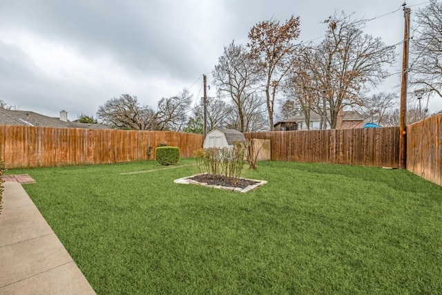 view of yard featuring a storage shed, an outdoor structure, and a fenced backyard