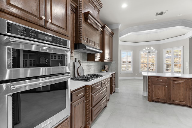 100 Bailee Ct, Forney, TX 75126 - kitchen with stainless steel appliances, a chandelier, a raised ceiling, decorative backsplash, and ornamental molding