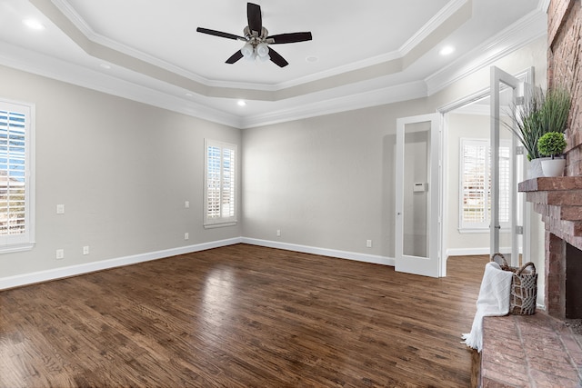 100 Bailee Ct, Forney, TX 75126 - unfurnished living room featuring a ceiling fan, dark wood-type flooring, a brick fireplace, a tray ceiling, and baseboards