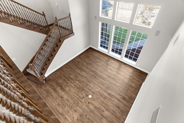 100 Bailee Ct, Forney, TX 75126 - unfurnished living room featuring baseboards, a towering ceiling, wood finished floors, and stairs
