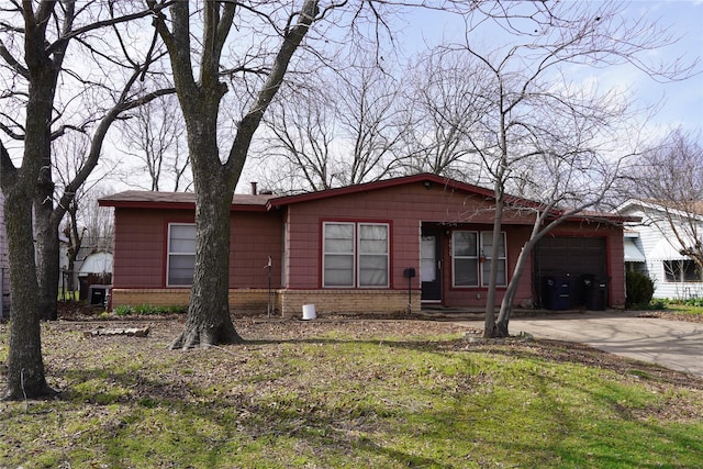 view of front of property featuring a garage, concrete driveway, and brick siding