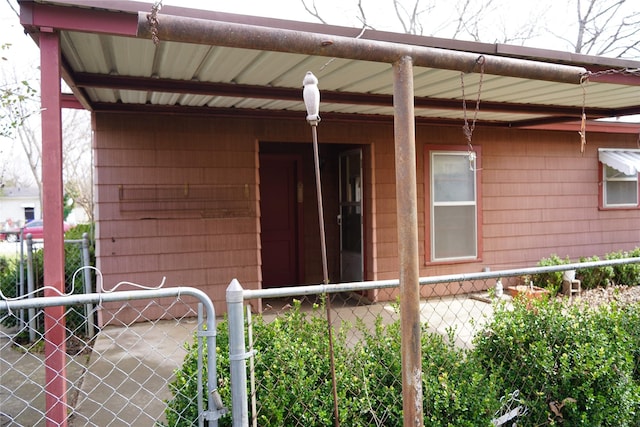 view of exterior entry featuring fence and a gate