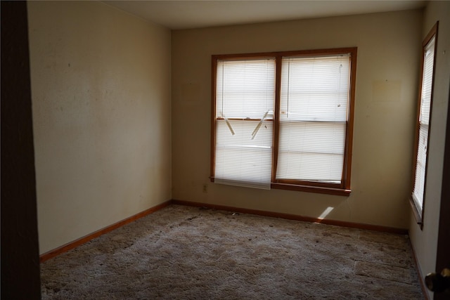 empty room featuring carpet floors and baseboards