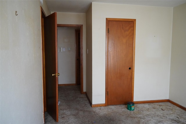 hallway featuring carpet floors and baseboards