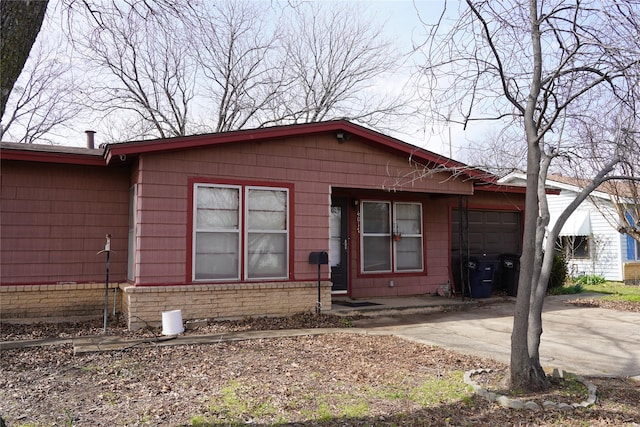 view of front of home with a garage, brick siding, and driveway