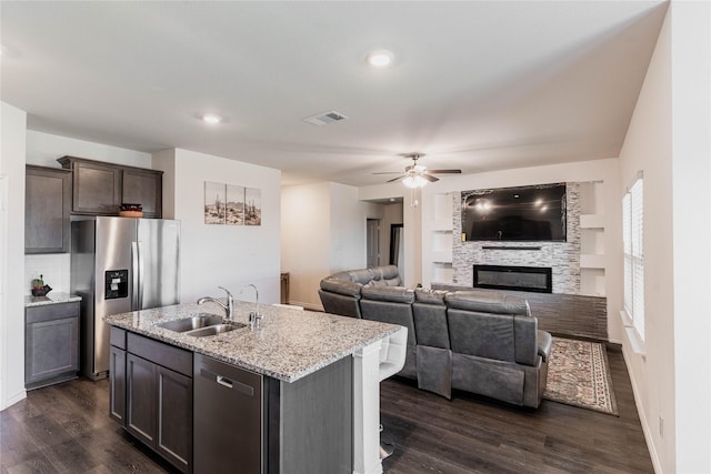 kitchen with stainless steel appliances, dark wood-style flooring, visible vents, and a sink