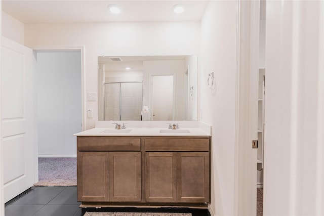 full bathroom with double vanity, a sink, visible vents, and a shower stall