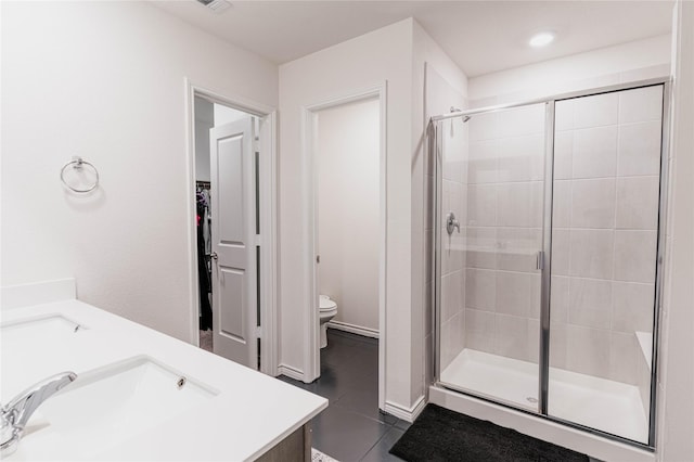 bathroom with a sink, tile patterned flooring, a shower stall, and toilet