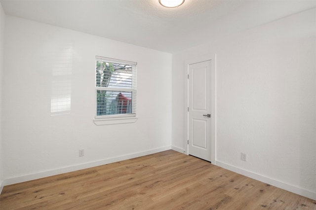 unfurnished room with light wood-style floors and baseboards