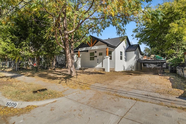 view of front of house featuring covered porch and fence