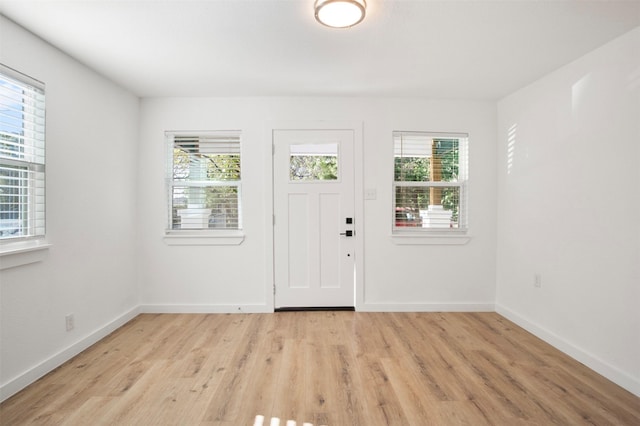 entrance foyer featuring baseboards, plenty of natural light, and light wood-style floors