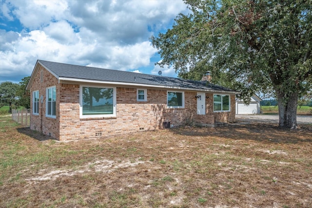 view of front of home with crawl space, brick siding, an outdoor structure, and a chimney