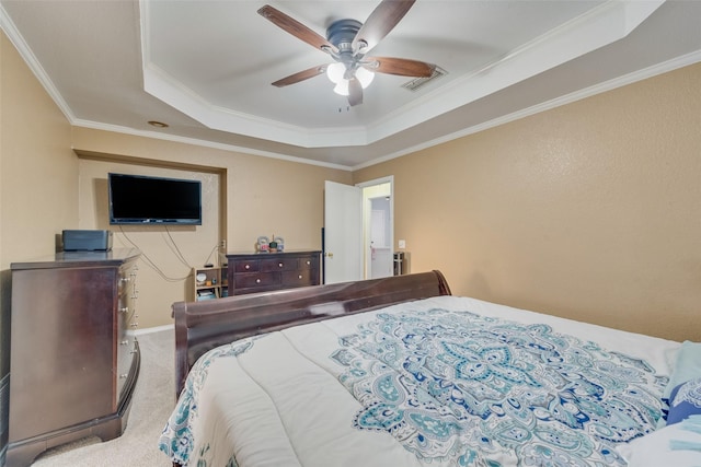 bedroom with carpet floors, crown molding, a raised ceiling, visible vents, and a ceiling fan