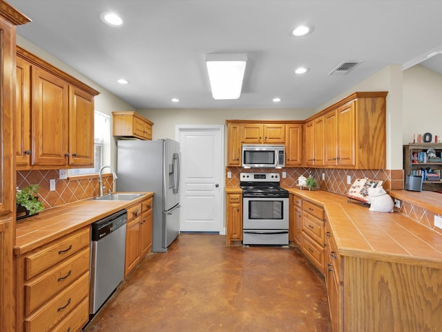 kitchen with visible vents, tile countertops, appliances with stainless steel finishes, a sink, and recessed lighting