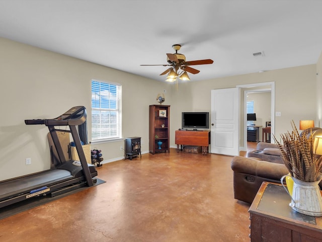 workout room with baseboards, visible vents, and ceiling fan