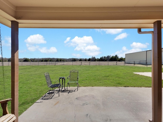 view of patio / terrace with a rural view and fence