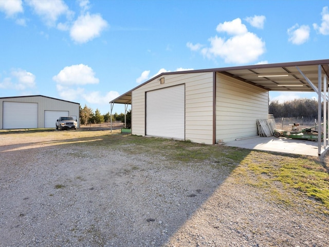 garage with a detached garage and fence