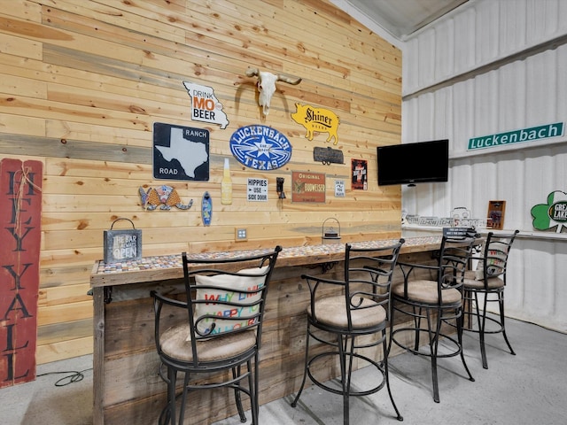 bar featuring concrete flooring and wet bar