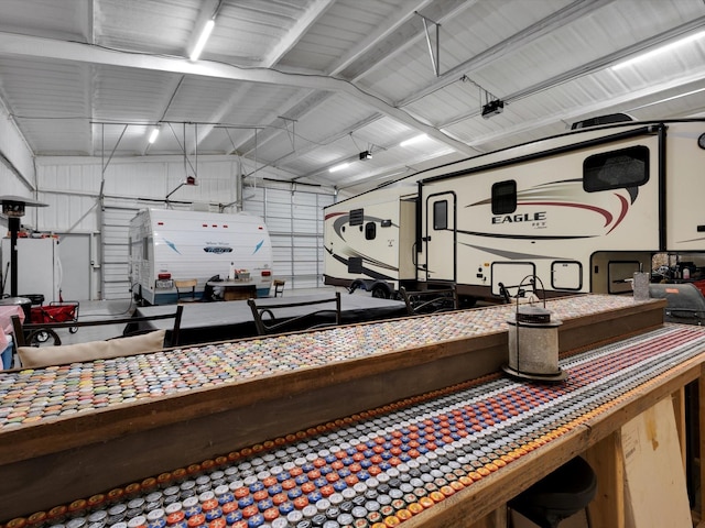 misc room featuring a garage, lofted ceiling, and metal wall