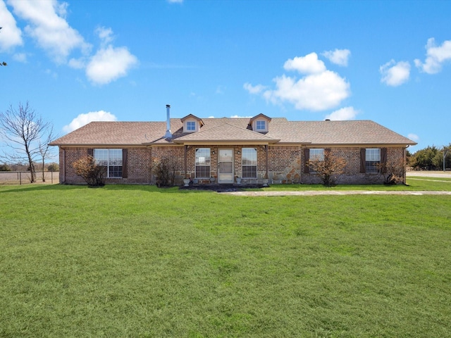 single story home with a shingled roof, brick siding, and a front lawn