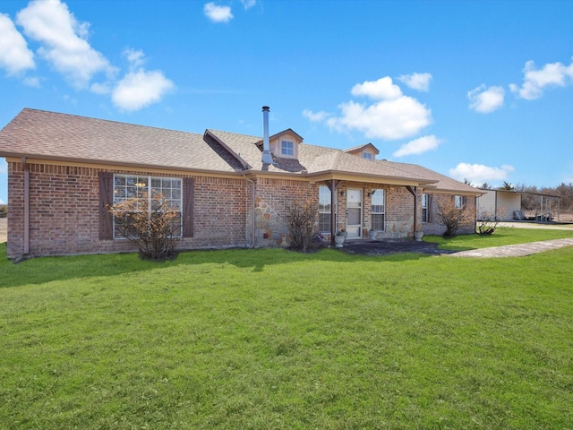 view of front of house featuring a shingled roof, a front lawn, and brick siding