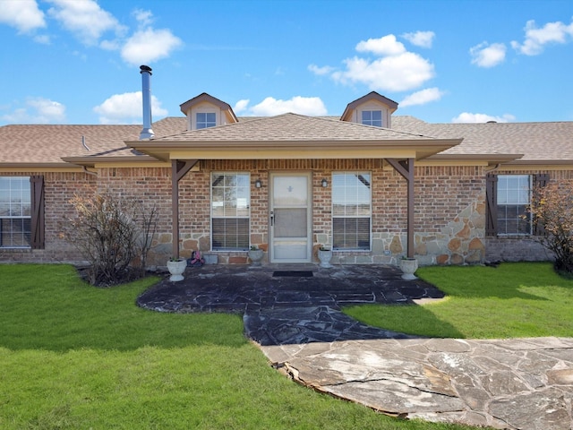 view of front of property with stone siding, roof with shingles, and a front yard