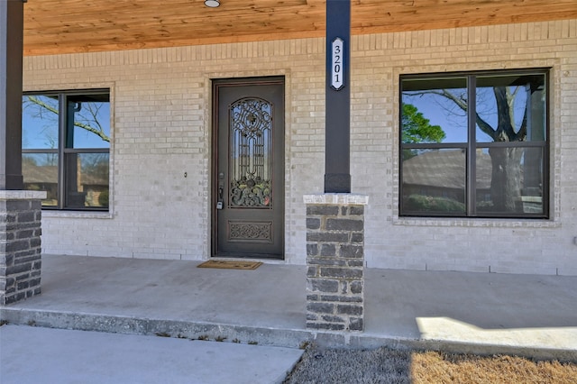 entrance to property featuring brick siding