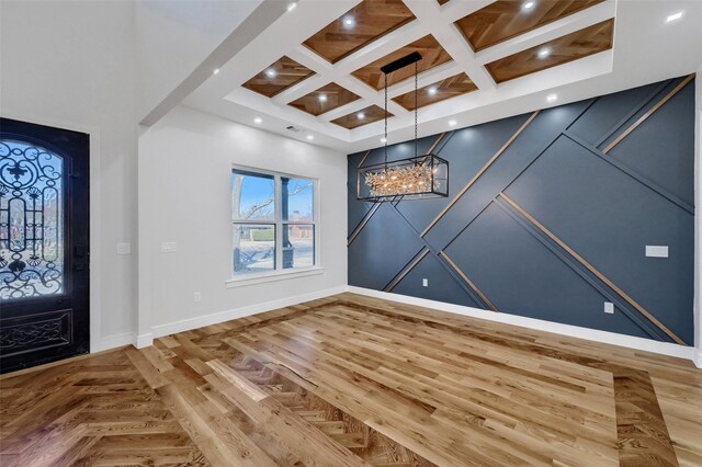 entryway with baseboards, coffered ceiling, a high ceiling, a chandelier, and recessed lighting