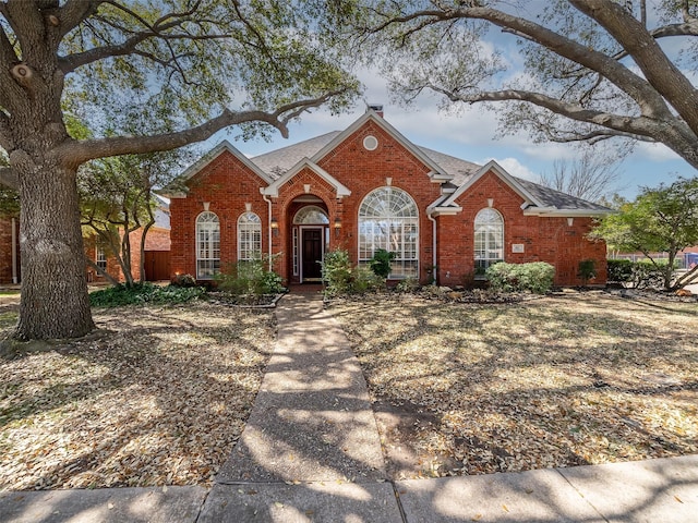 view of front of home with brick siding and a shingled roof