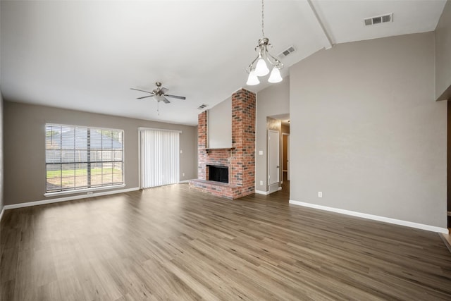 unfurnished living room featuring a brick fireplace, visible vents, baseboards, and wood finished floors