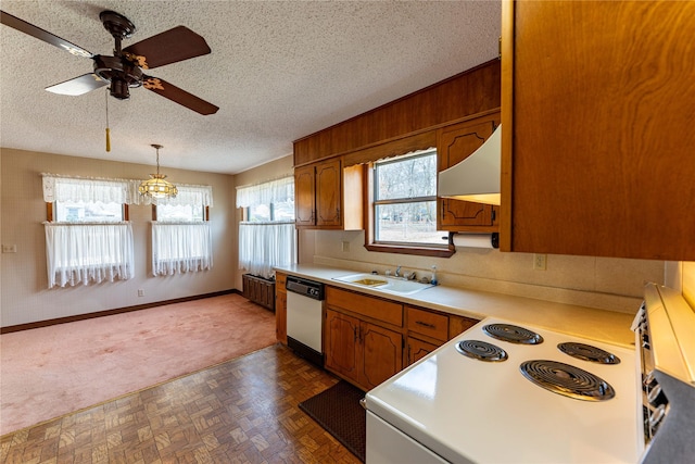 kitchen with white appliances, brown cabinets, light countertops, a textured ceiling, and a sink