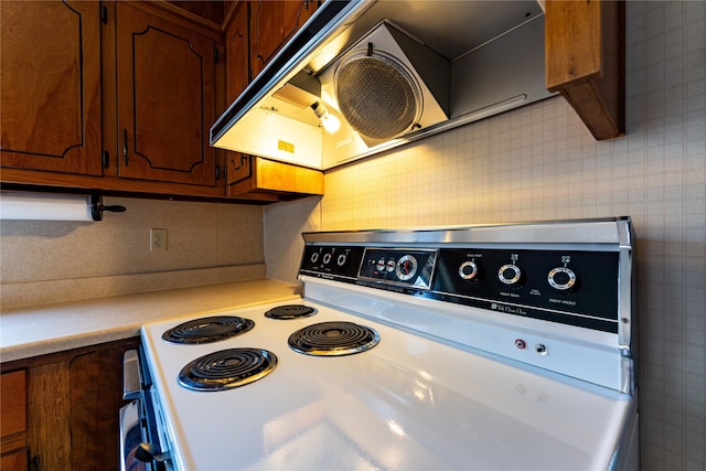 kitchen with tile walls, light countertops, decorative backsplash, range with electric cooktop, and extractor fan