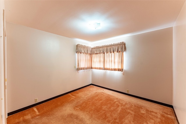 unfurnished room with carpet floors and baseboards