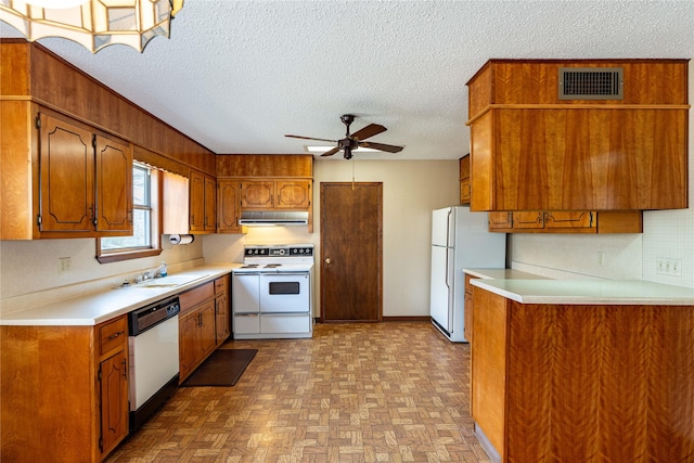 kitchen with extractor fan, white appliances, a sink, visible vents, and brown cabinets