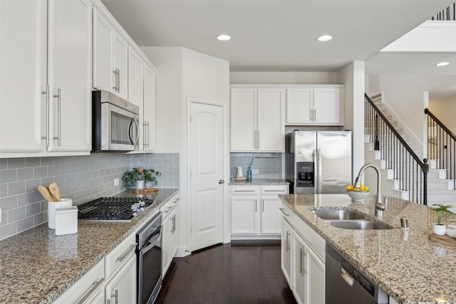 kitchen with white cabinets, dark wood-style floors, stainless steel appliances, a sink, and recessed lighting