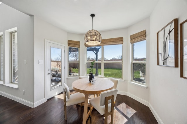 dining space featuring dark wood-style floors, baseboards, and a chandelier