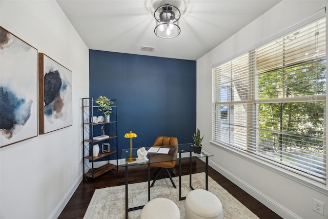 office space featuring wood finished floors, visible vents, and baseboards