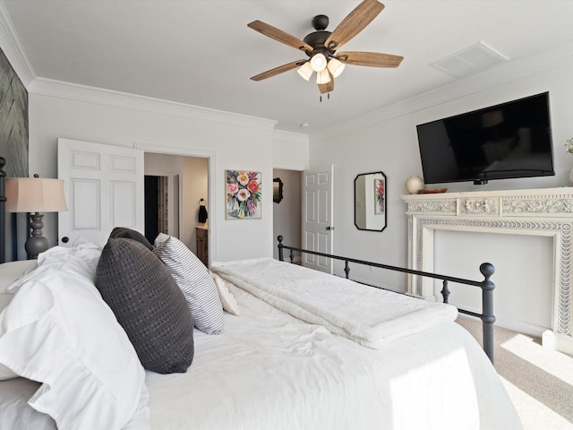 carpeted bedroom with a ceiling fan, visible vents, crown molding, and ensuite bathroom