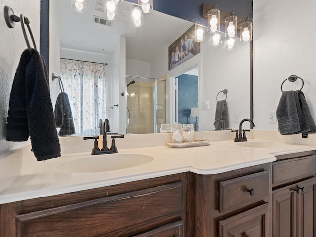 full bath featuring double vanity, a stall shower, visible vents, and a sink