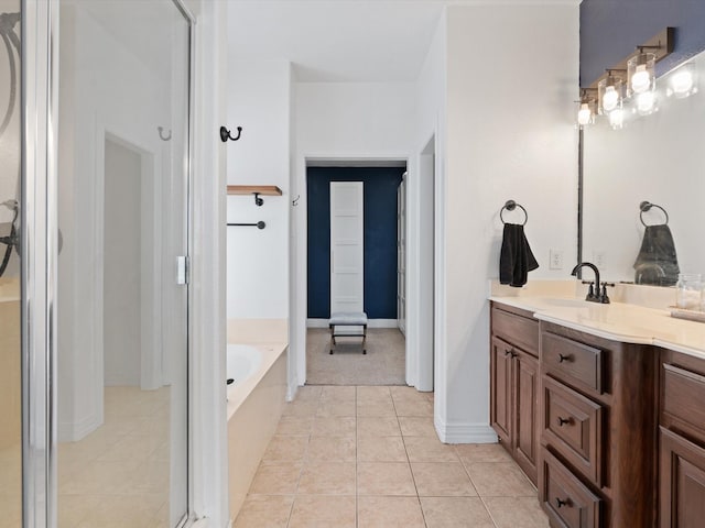 bathroom featuring a garden tub, tile patterned flooring, baseboards, and vanity