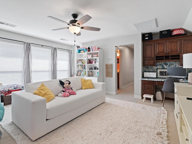 living room with light carpet, built in desk, and visible vents