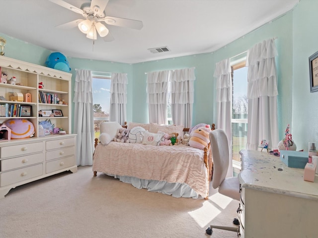 bedroom featuring carpet floors, multiple windows, visible vents, and a ceiling fan