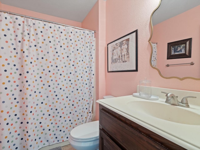 bathroom featuring toilet, curtained shower, and vanity