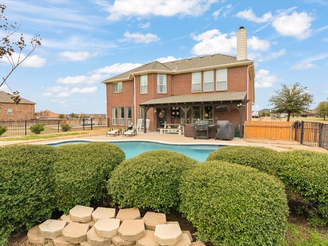 view of pool with a patio area, a fenced backyard, a fire pit, and a fenced in pool